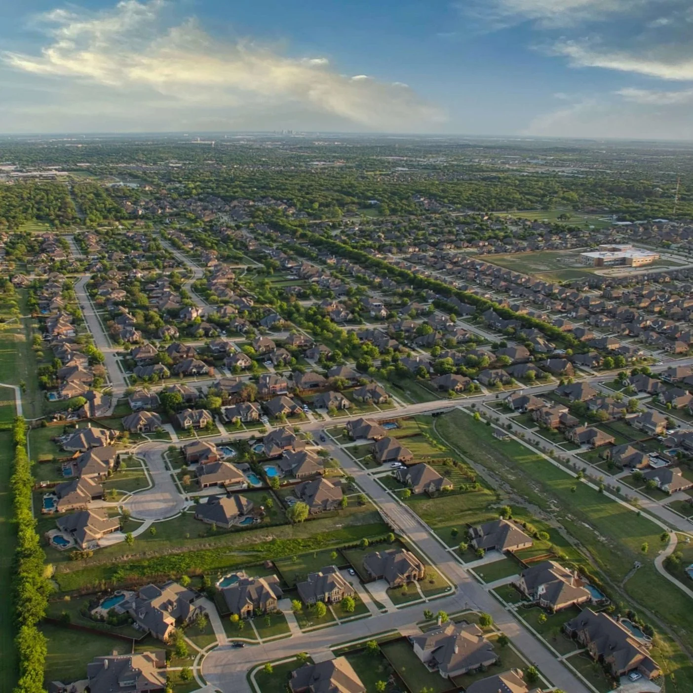Aerial drone view of a luxury residential neighborhood in Lakeway, Texas, showcasing pristine landscape maintenance and estate management by 360 Landscapes.