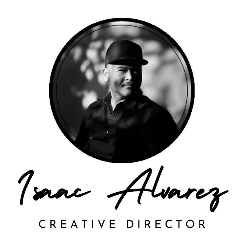 Black and white portrait of Isaac Alvarez, a creative director, wearing a cap and jacket, with a blurred outdoor background.