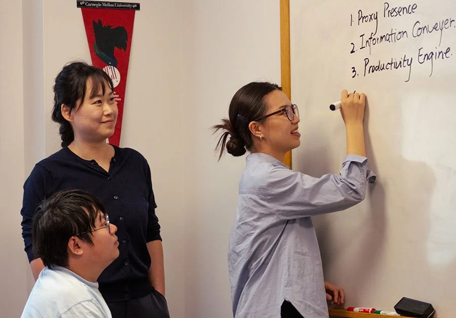 Woman writing on a whiteboard with a black marker