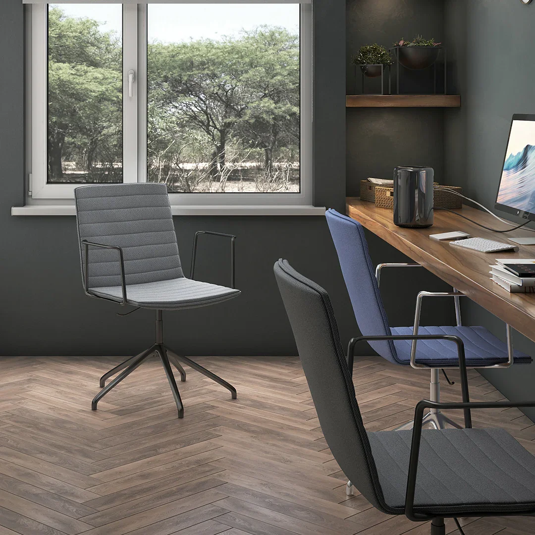 Oficina moderna con escritorio de madera, varias sillas de oficina de diferentes colores, una computadora y plantas decorativas en estantes.