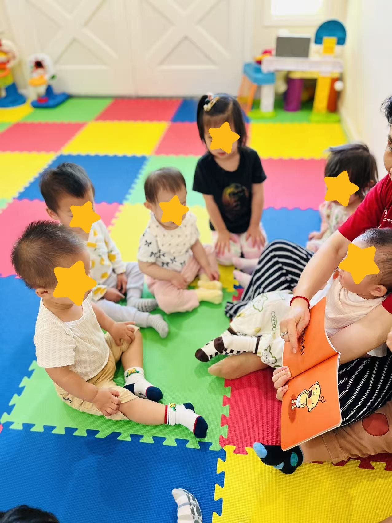 Children listening to a story at Red Apple Daycare, supporting language development and early literacy skills.
