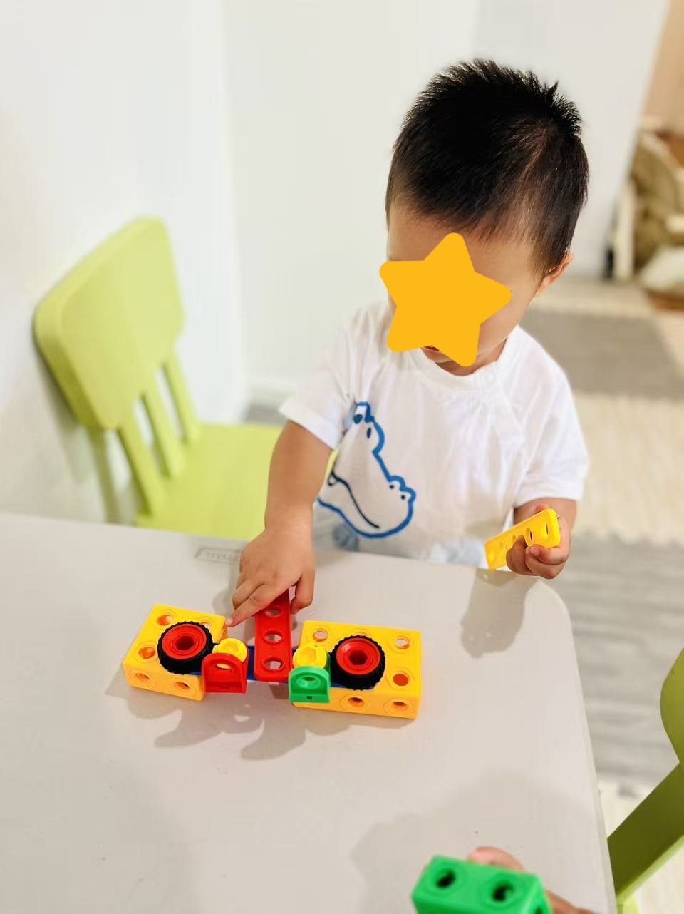 Child building with blocks during hands-on learning activities at Red Apple Daycare, supporting fine motor skill development.