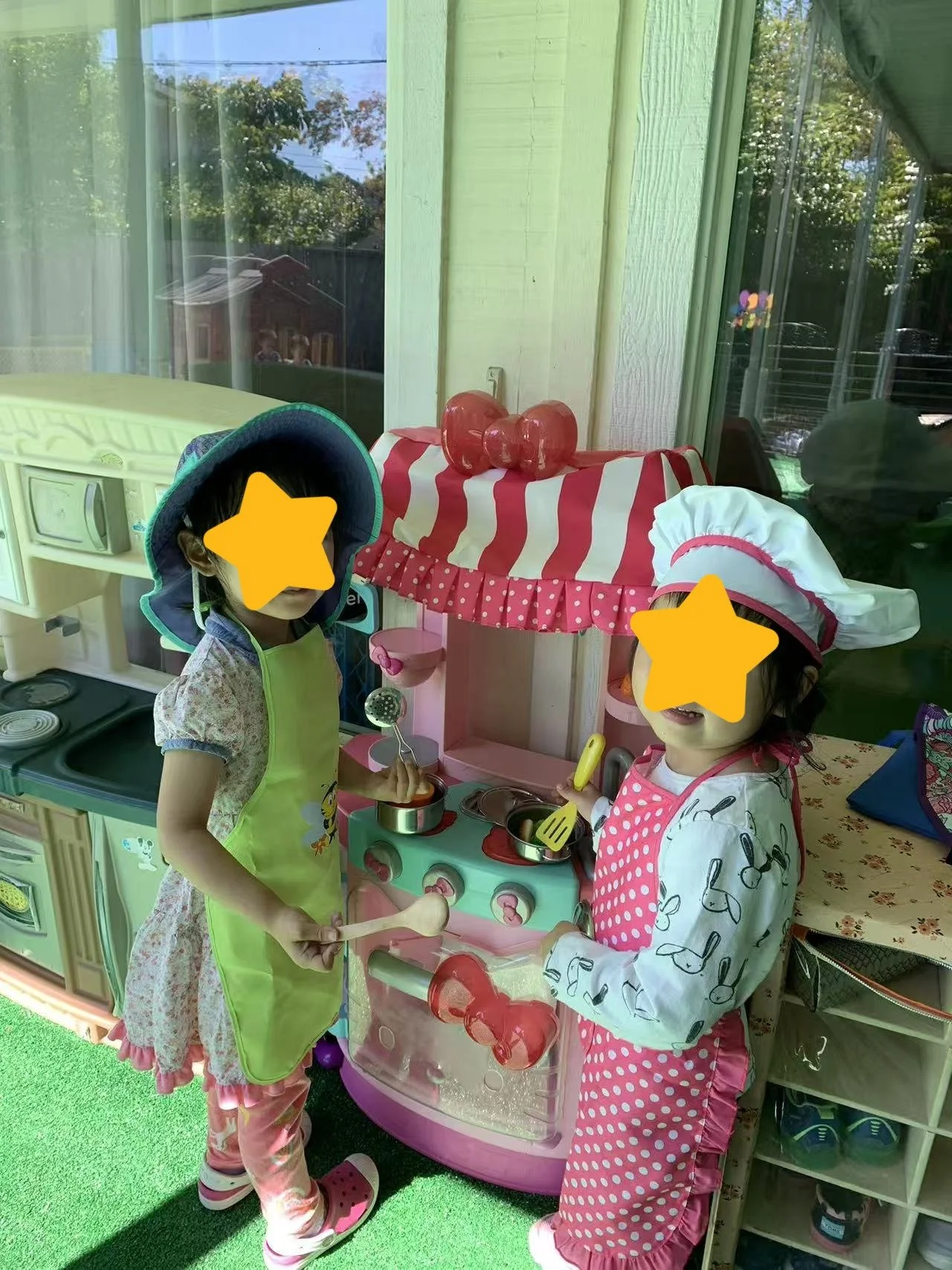 Children engaging in pretend play at Red Apple Daycare in Santa Clara, using a toy kitchen to develop creativity and social skills.