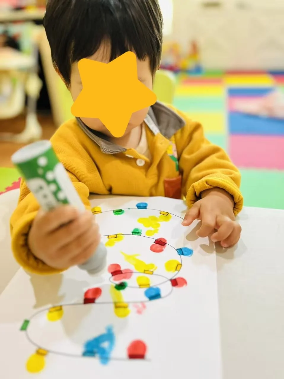 Child participating in art activities at Red Apple Daycare, developing fine motor skills and creativity through hands-on learning.
