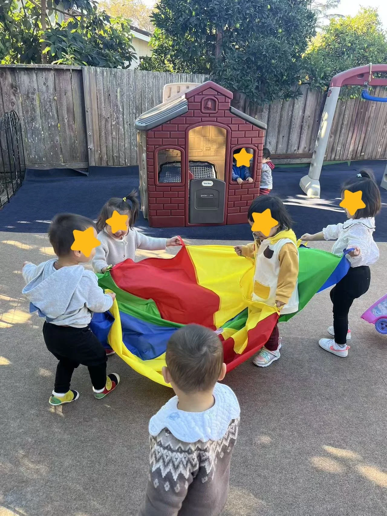 Children playing a cooperative outdoor game at Red Apple Daycare, supporting teamwork and gross motor development.
