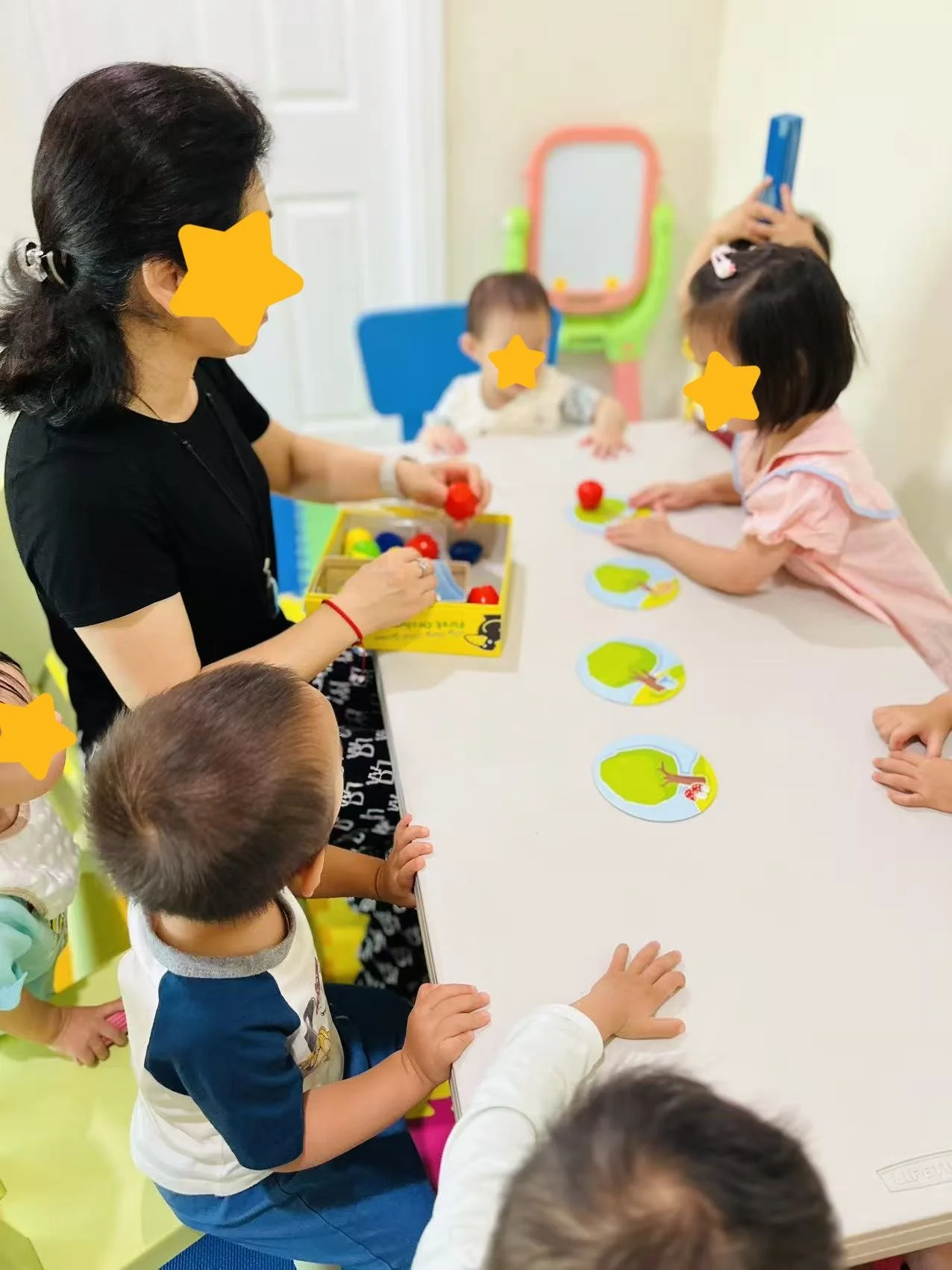 Children participating in supervised small-group activities at Red Apple Daycare, supporting early learning and attention skills.
