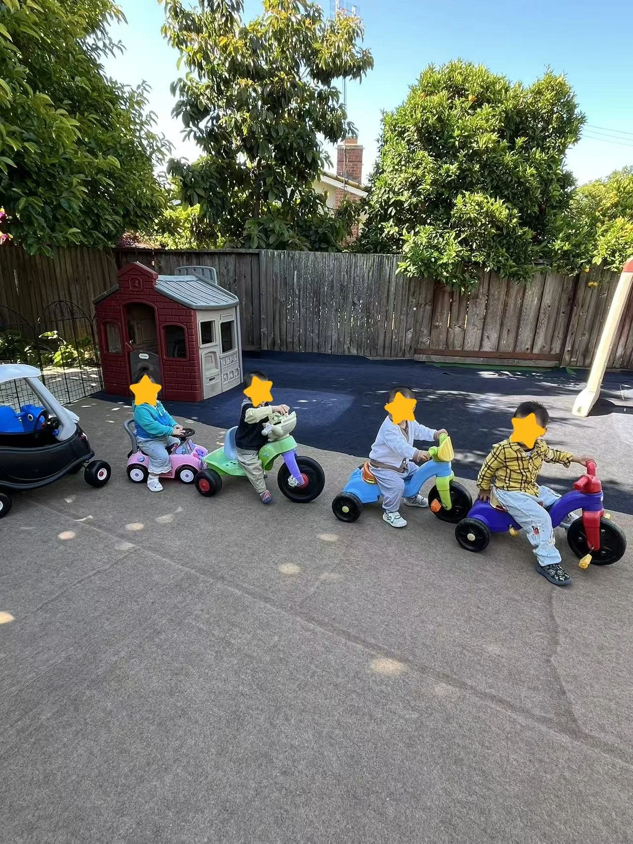 Children riding tricycles at Red Apple Daycare in Santa Clara, supporting balance, coordination, and outdoor play.
