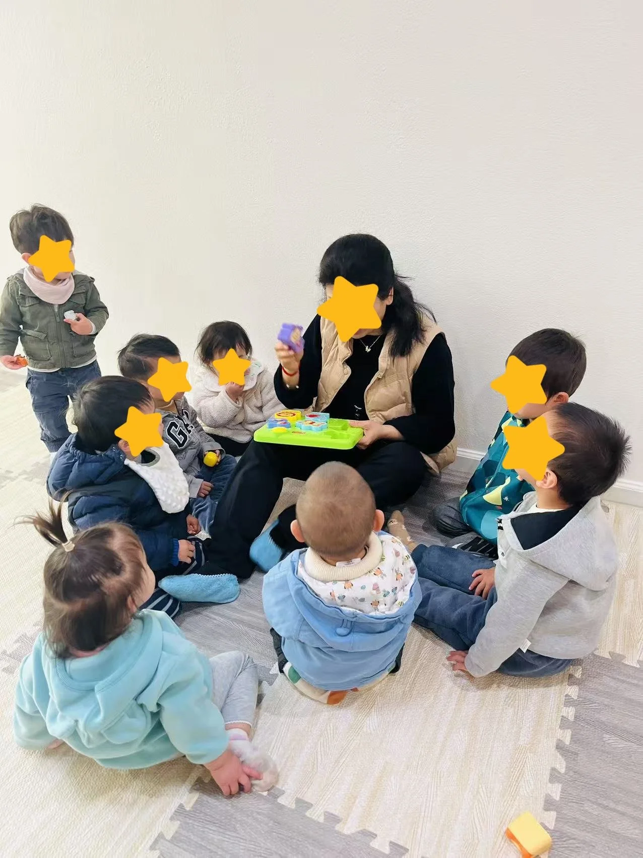 Teacher reading to children during storytime at Red Apple Daycare in Santa Clara, supporting language development and listening skills.
