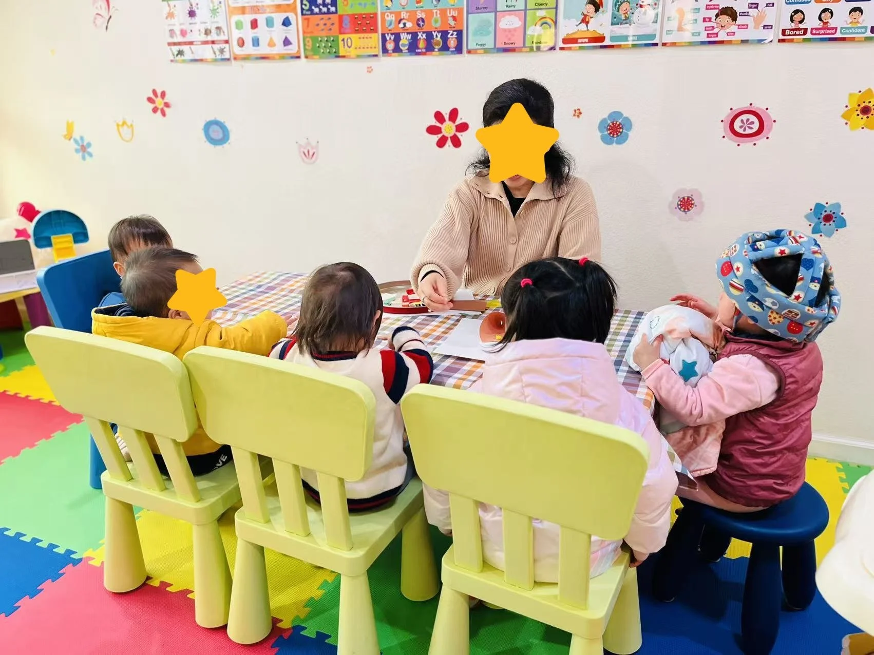 Children engaged in classroom learning with a teacher at Red Apple Daycare in Santa Clara, supporting focus and early learning skills.