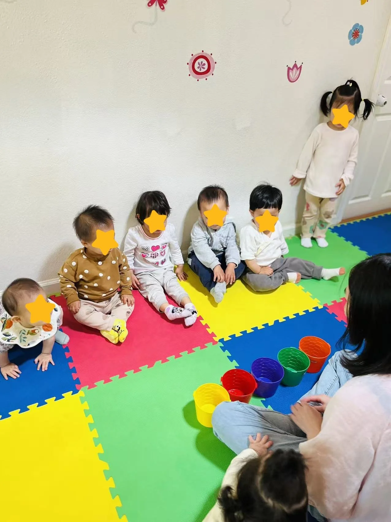 Teacher guiding a small group activity at Red Apple Daycare, supporting social interaction and early learning.
