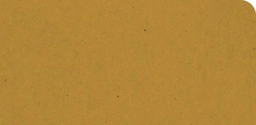 Close-up of a gold-colored metallic or paper surface with slight texture and small black spots.