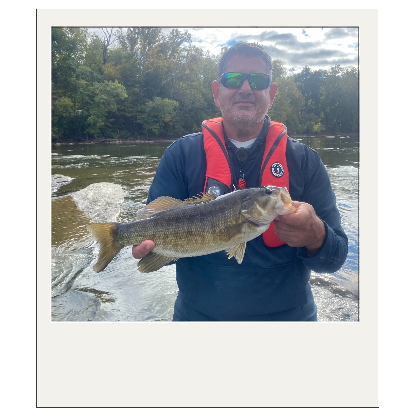 Angler in red life vest showing off bass landed on a Potomac River float with White Fly Outfitters.