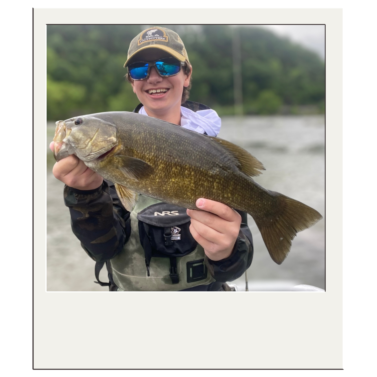 Fisherman holding a trophy bass during a guided fly-fishing trip with White Fly Outfitters.