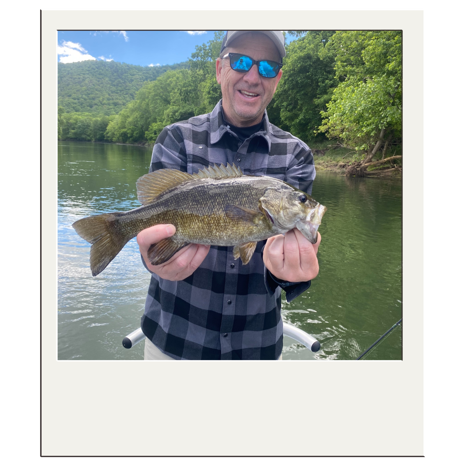 Smiling fisherman after catching a strong smallmouth bass with White Fly Outfitters.
