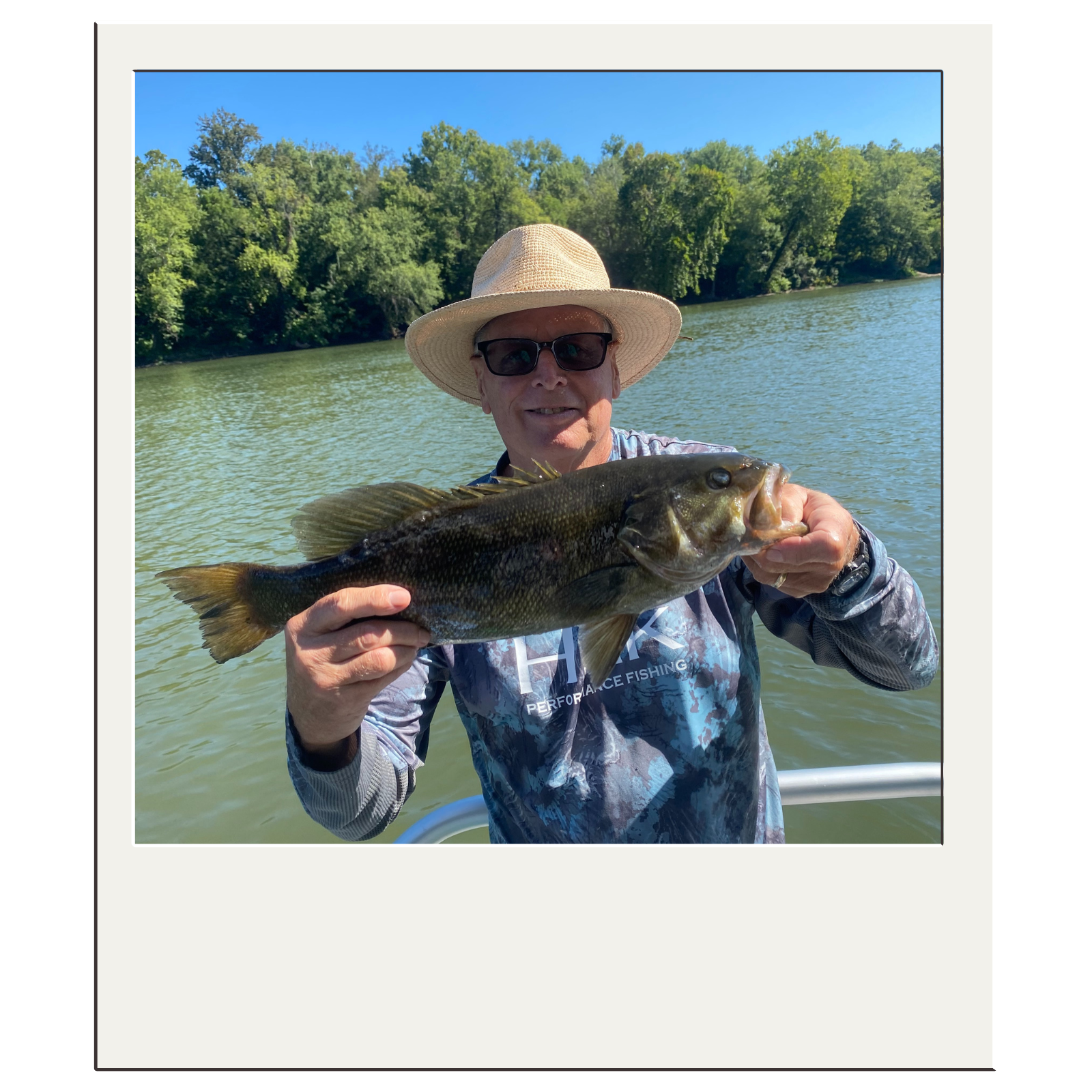 Fly-fishing guest holding a smallmouth bass on a sunny day near Harpers Ferry.