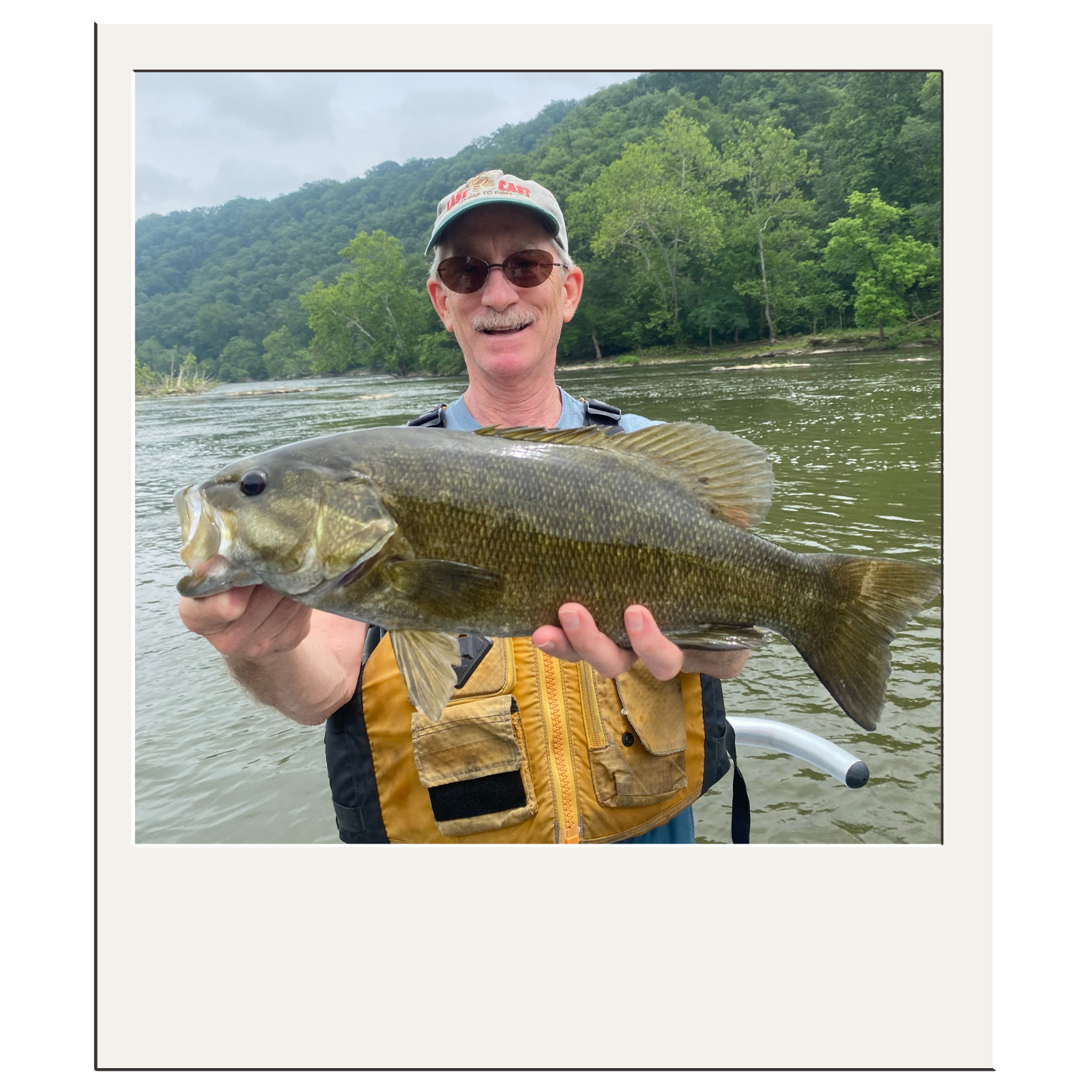 Smiling angler holding a bass caught during a guided Harpers Ferry river float.