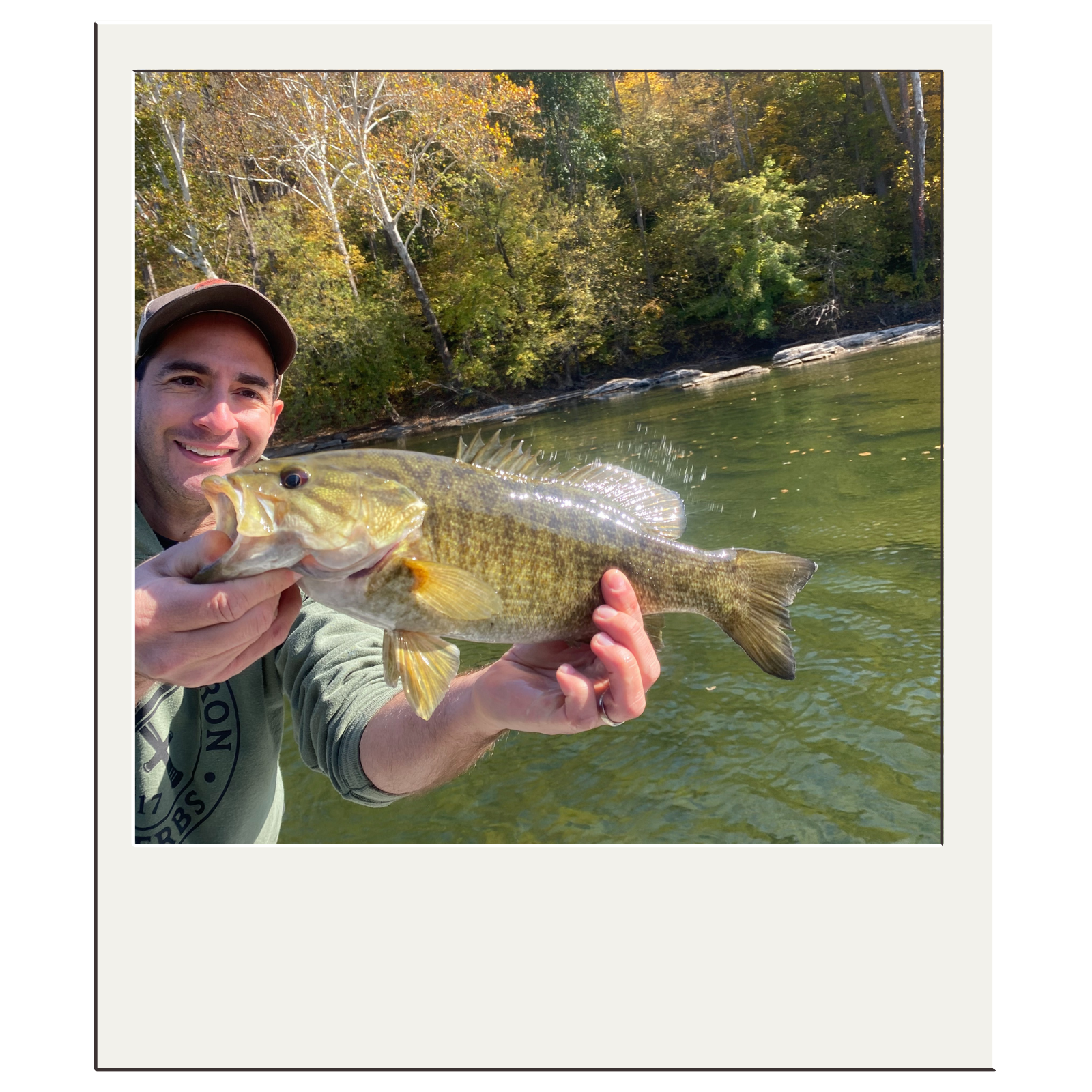 Smiling angler presenting a bass caught during a White Fly Outfitters Harpers Ferry fly-fishing trip.