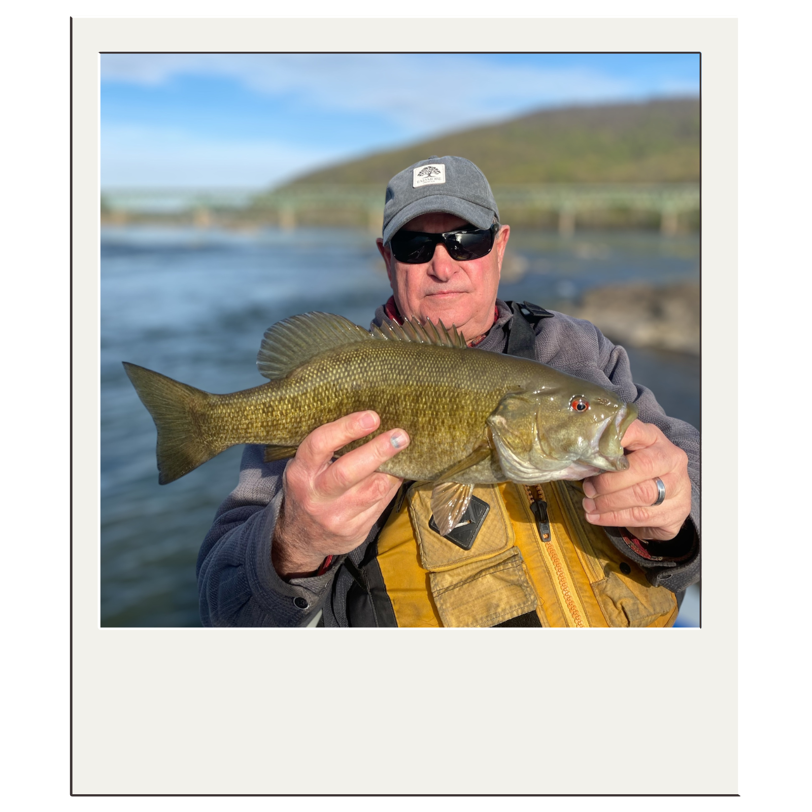 Smiling fisherman with smallmouth bass on a sunny Harpers Ferry fly-fishing day.