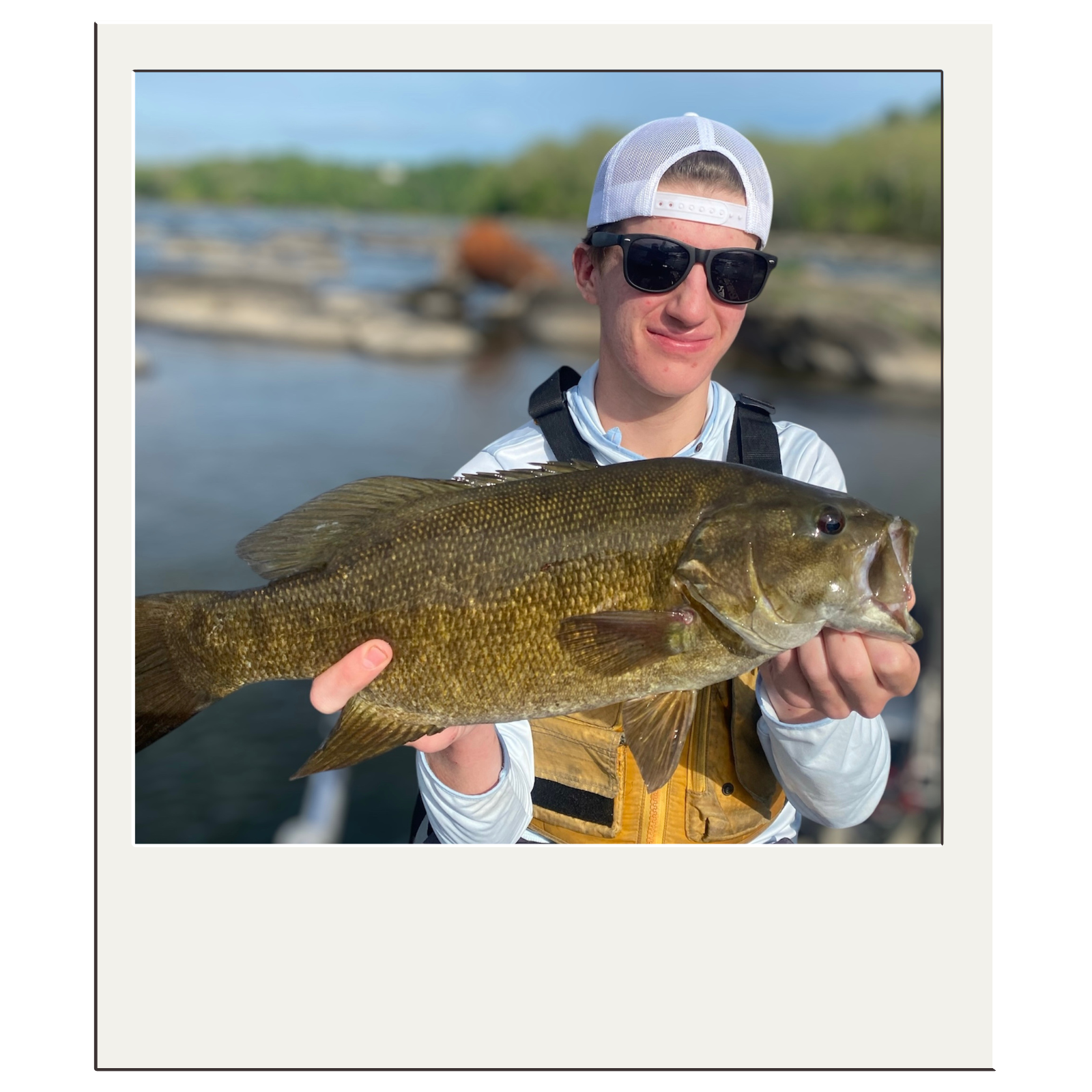 Fisherman in white cap presenting bass caught on fly near Harpers Ferry in the WV panhandle.
