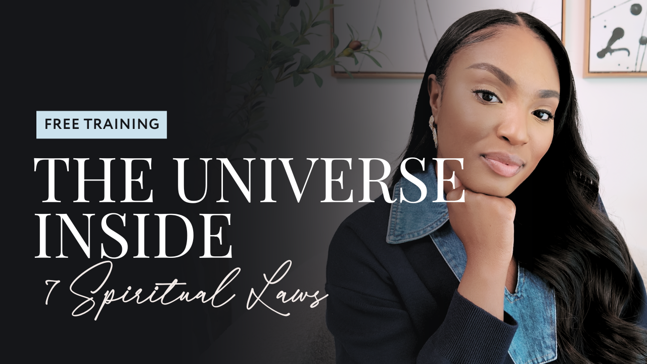 A woman with long dark hair, wearing a denim shirt and blazer, sitting indoors, resting her chin on her hand, with framed artwork on the wall behind her.