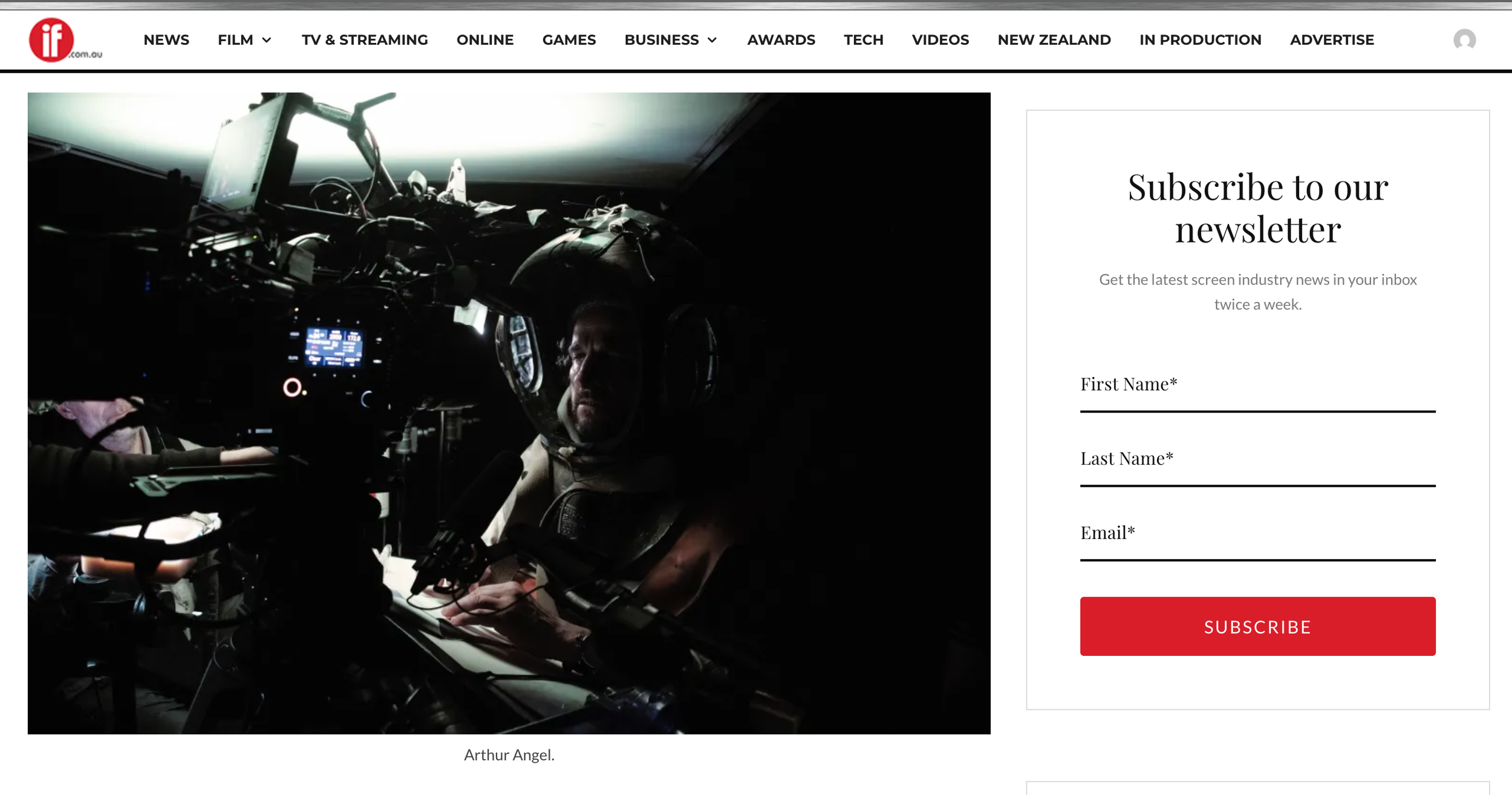 Actor Arthur Angel  in rig to shoot first person POV shot with a cutaway helmet, seated inside a set  surrounded by advanced technical equipment and screens.