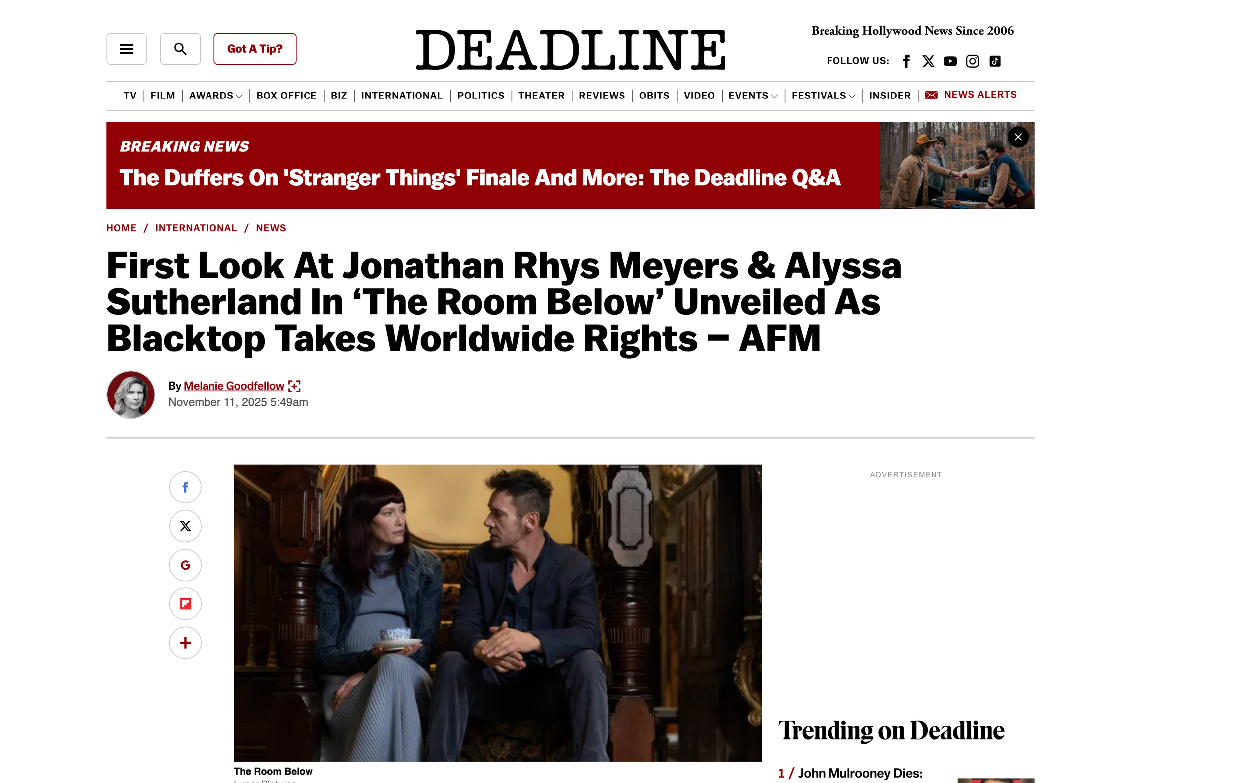 Screenshot of the Deadline news website article with a headline about the characters Jonathan Rhys Meyers and Alyssa Sutherland from 'The Room Below'. The page shows a photo of a man and a woman sitting on a staircase inside a house, engaging in a se