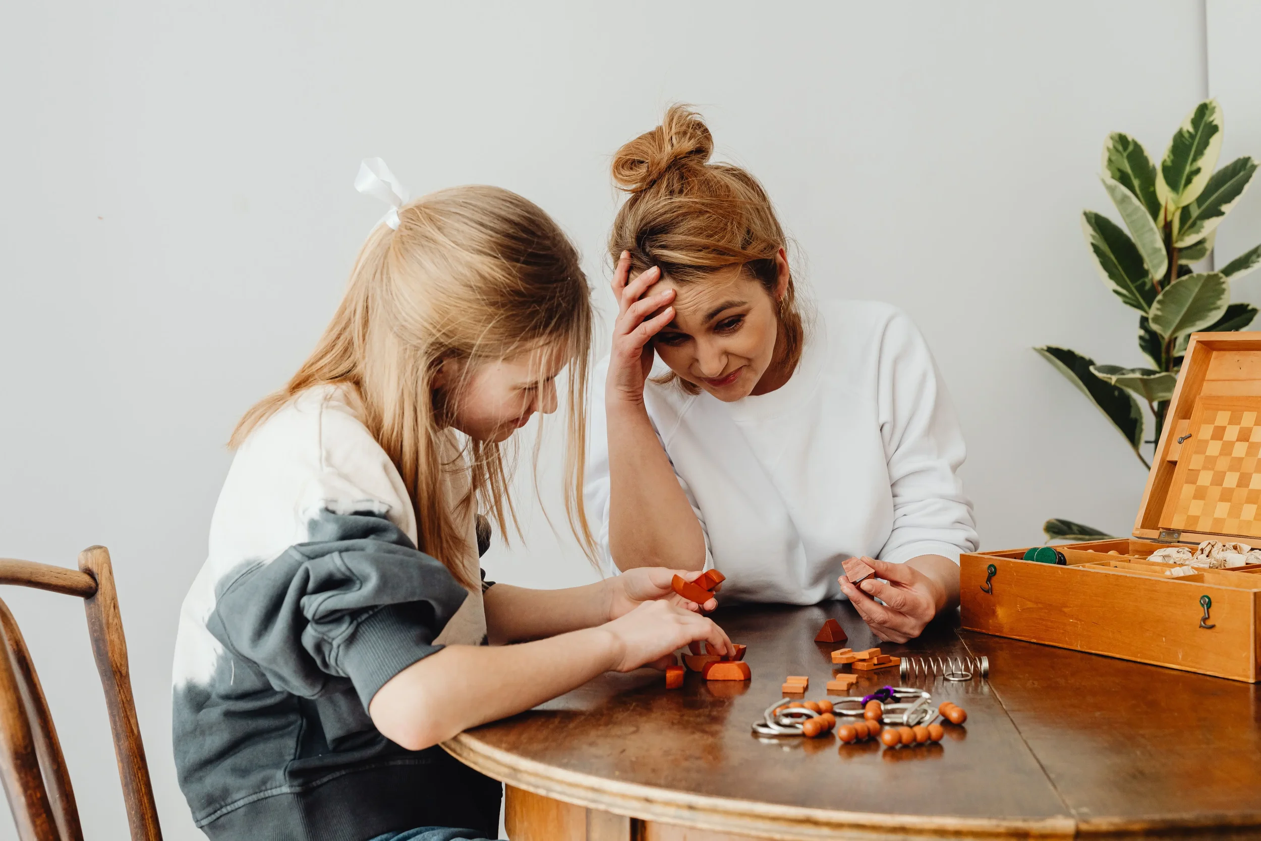 Parent and child working through a tabletop puzzle together after a child’s ADHD diagnosis, reflecting support and practical next steps.