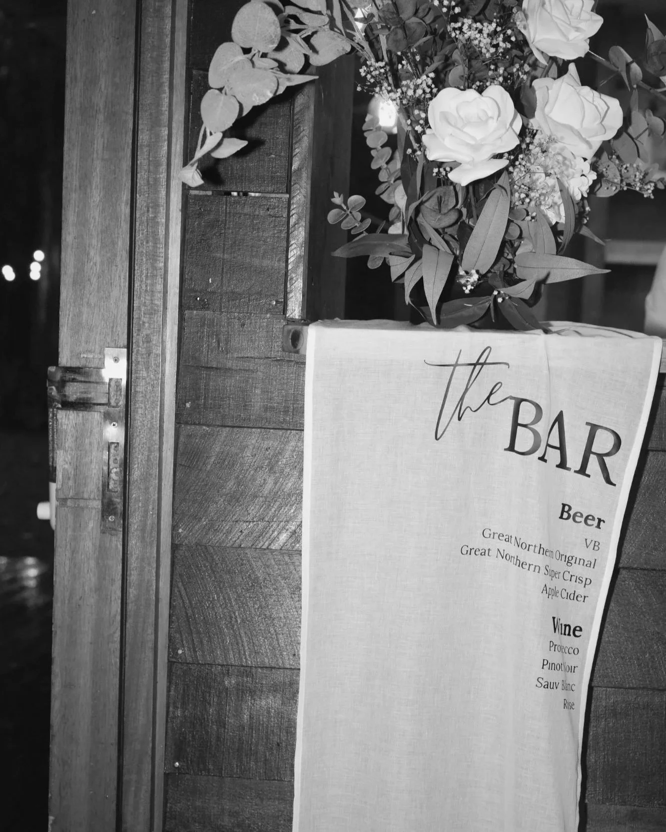 Bar styling detail with floral arrangement and custom drink menu signage at a Gold Coast wedding styled by Saudade Events.