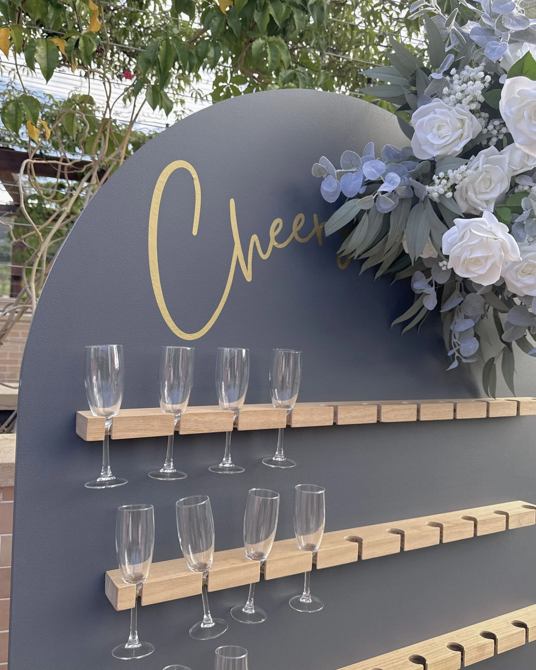 Custom wedding champagne wall with floral installation and personalised signage in Gold Coast by Saudade Events.