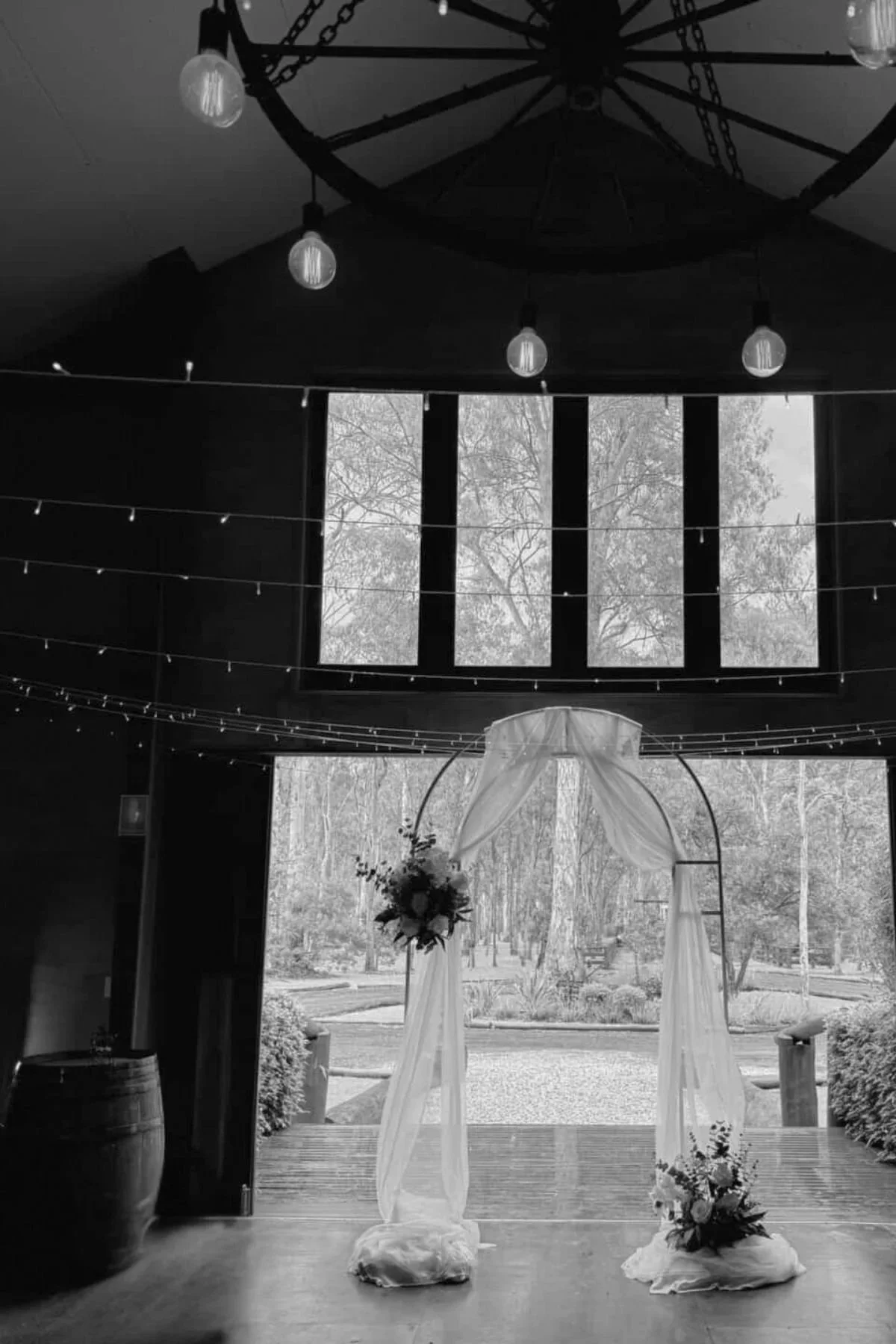 Elegant indoor wedding ceremony setup with draped arch and florals by Saudade Events on the Gold Coast.