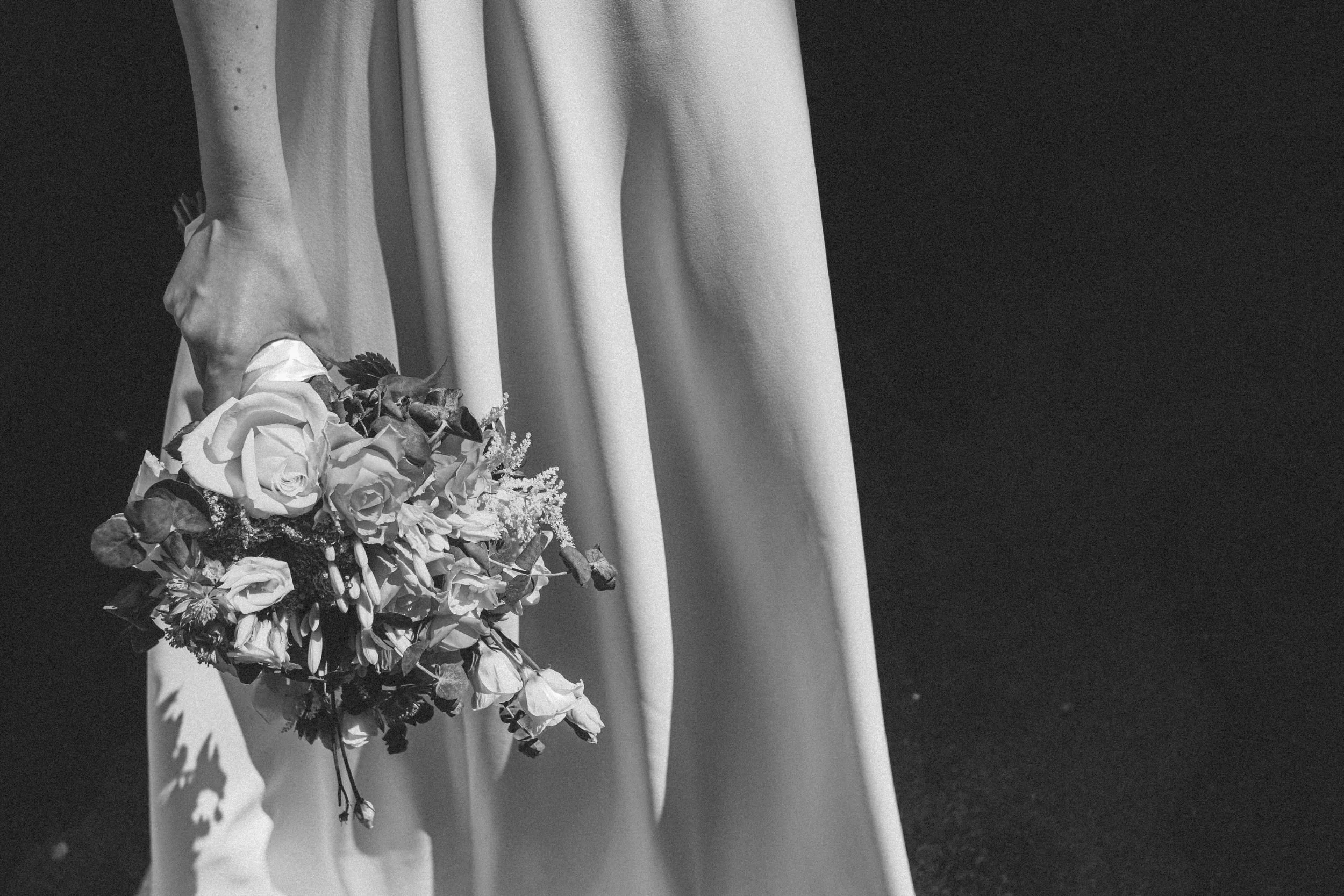Bride holding a white rose bouquet in soft black and white, reflecting the romantic, design-led aesthetic of Saudade Events, Gold Coast wedding and event stylist.