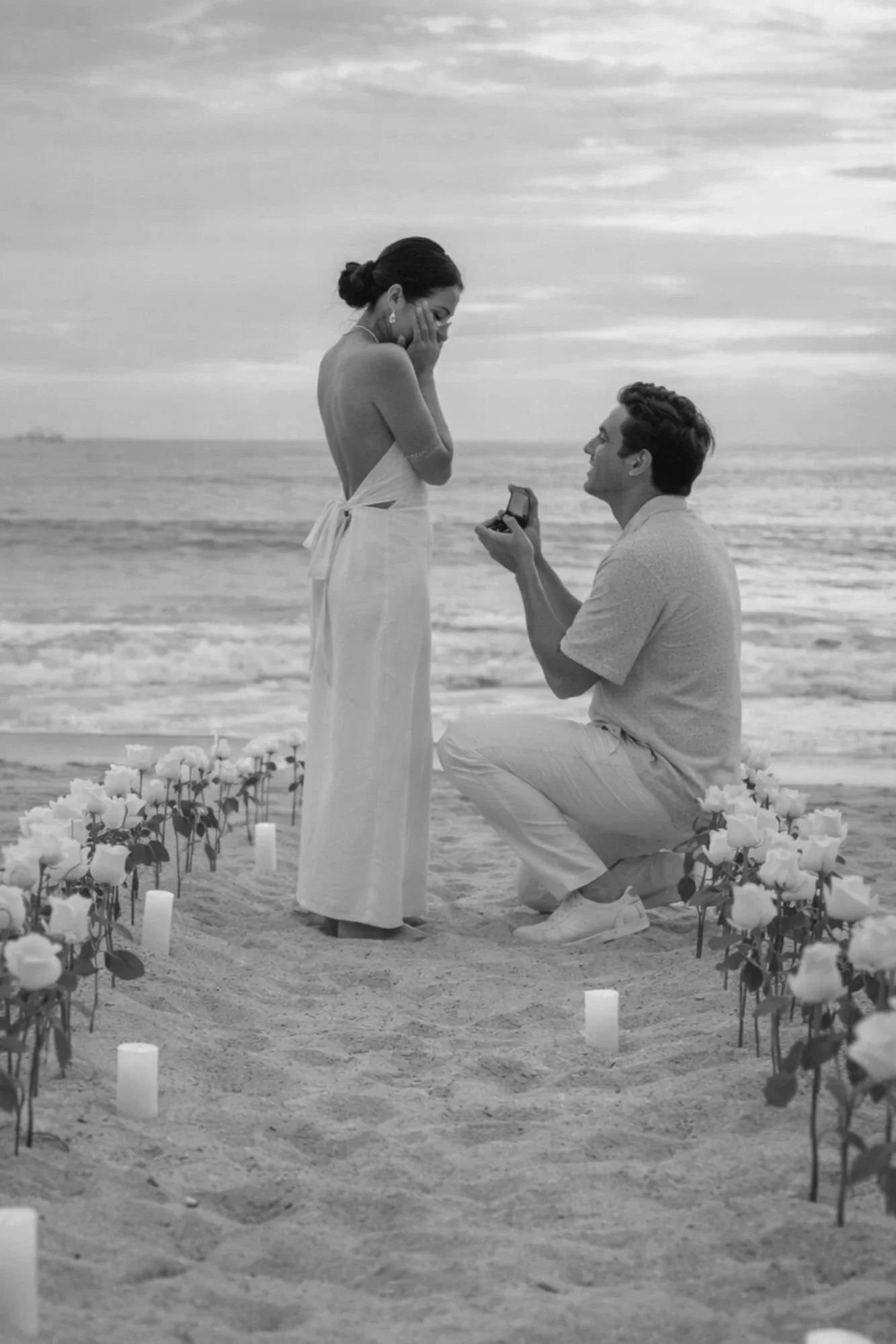 Beach proposal setup with white rose aisle and candles styled by Saudade Events, Gold Coast engagement stylist.