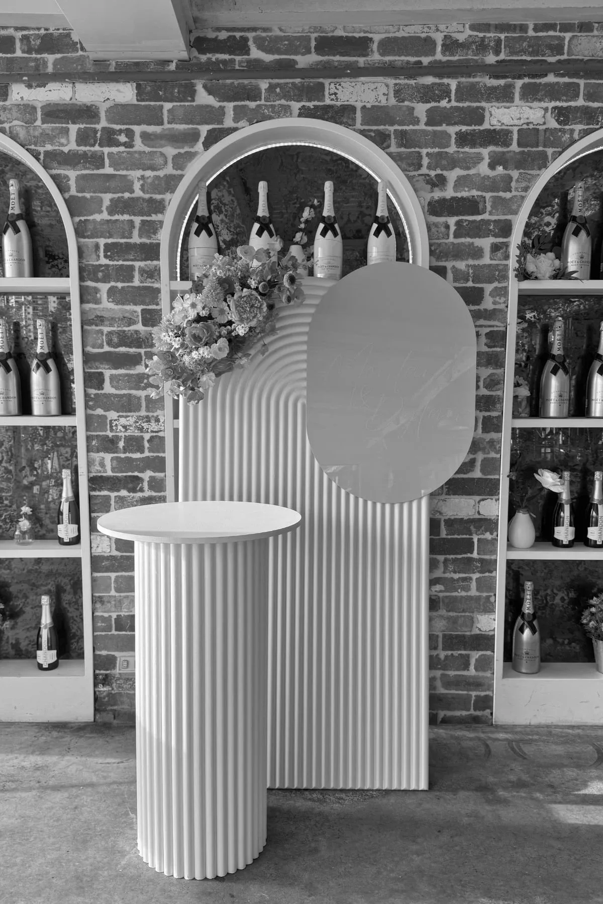 Custom celebration backdrop and plinth styling with florals at a Gold Coast event by Saudade Events.