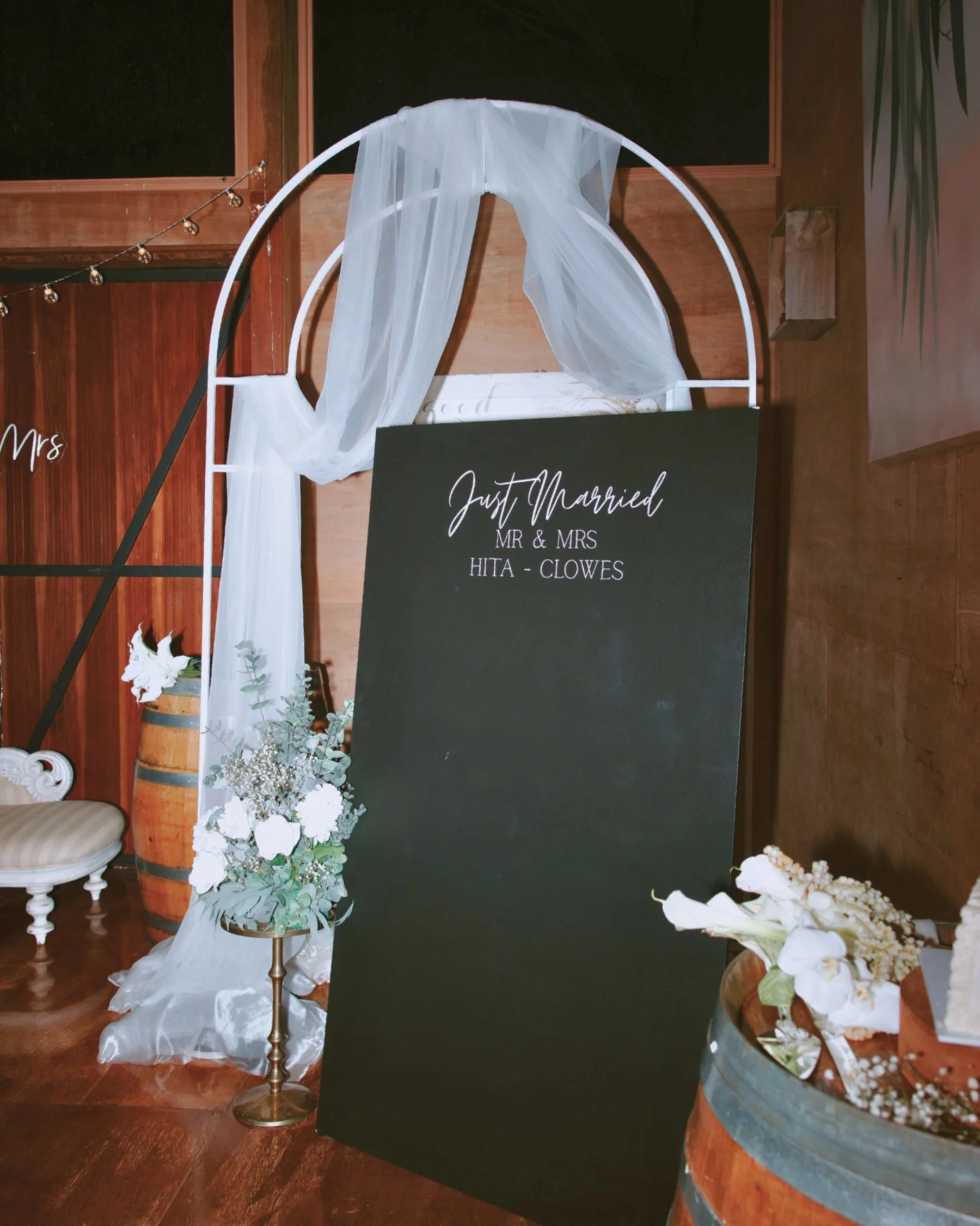 Custom wedding welcome sign with white draped arbour and floral styling in Gold Coast by Saudade Events.