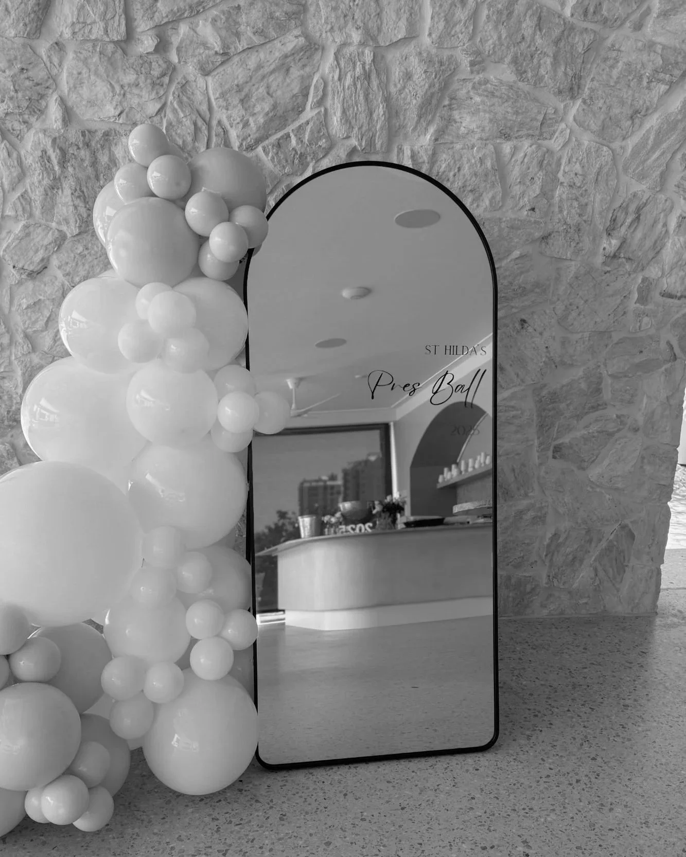 Organic balloon garland installation with mirror signage for balloon styling at a Gold Coast event by Saudade Events.