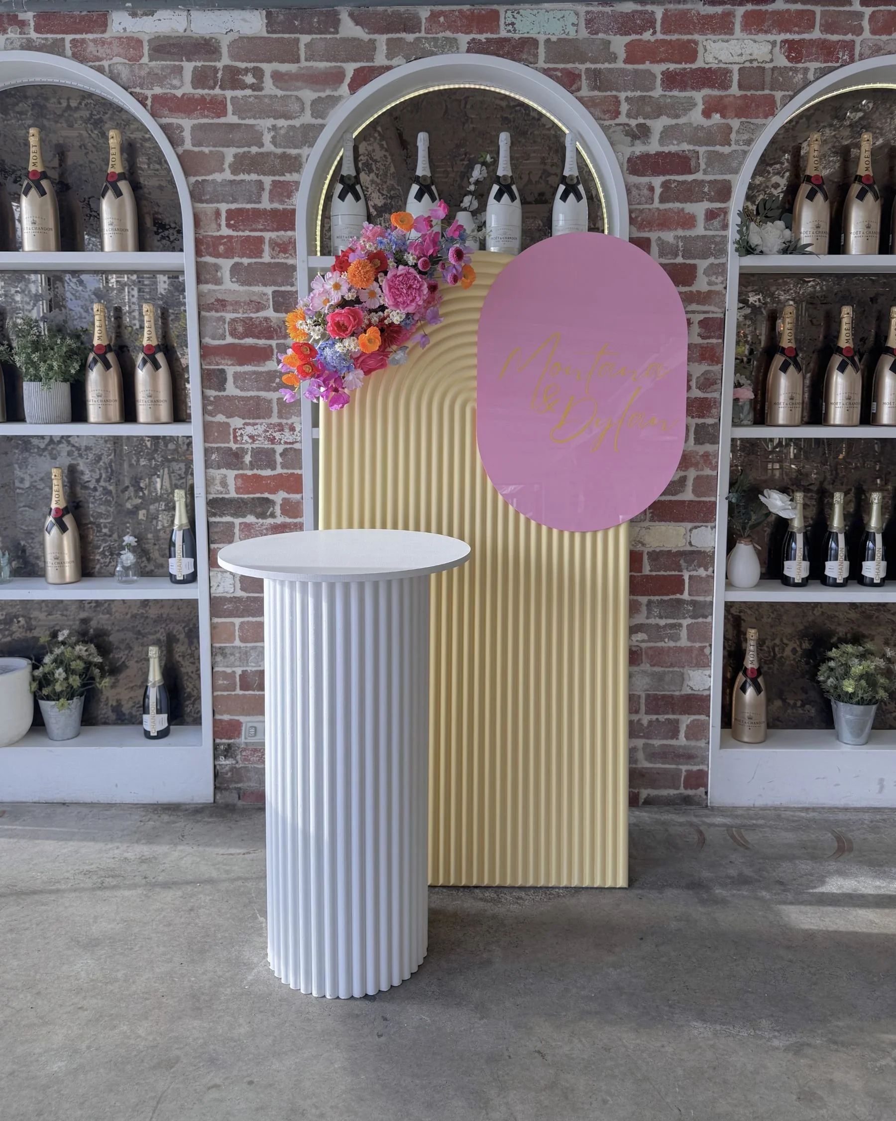 Surprise elopement backdrop styling at Surfers Pavilion Gold Coast featuring custom arched panels and vibrant floral installation by Saudade Events.