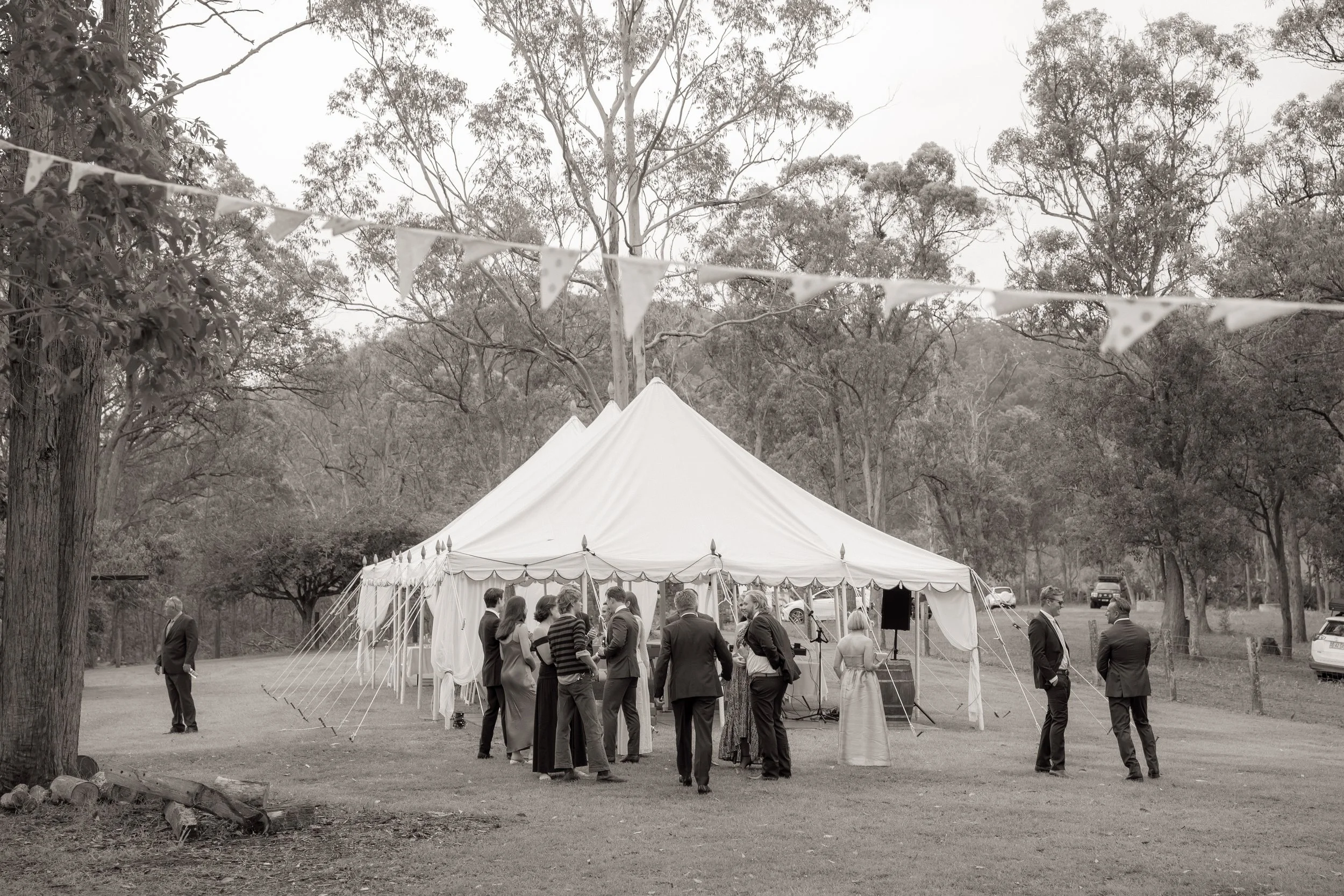 Wedding guests seated at a long outdoor table sharing a farm-style dinner under the marquee at Kingaley, Hunter Valley