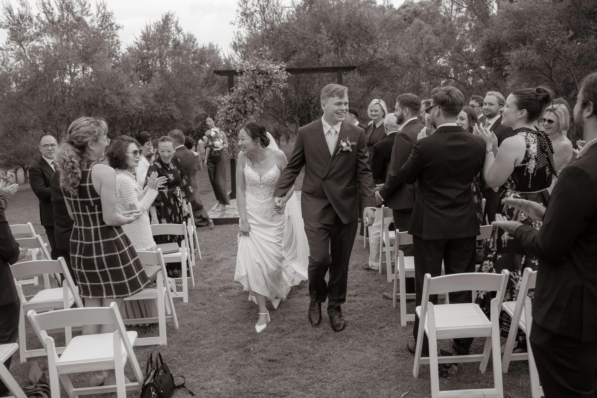 Bride and groom walking back down the aisle as guests applaud at an outdoor wedding ceremony, Kingaley Farm Stay Hunter Valley