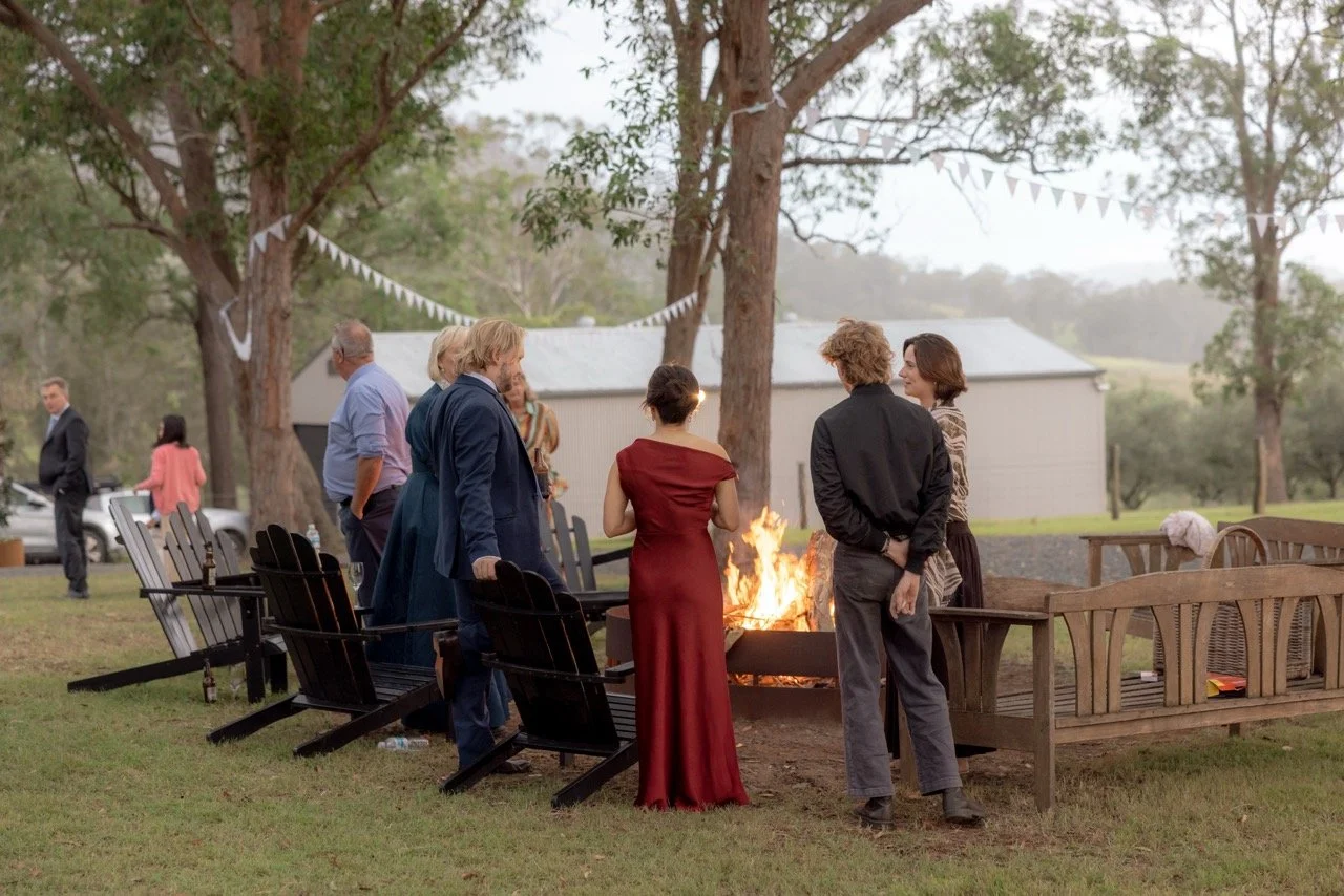 Wedding guests gathered around the fire pit in the evening at Kingaley Farm Stay