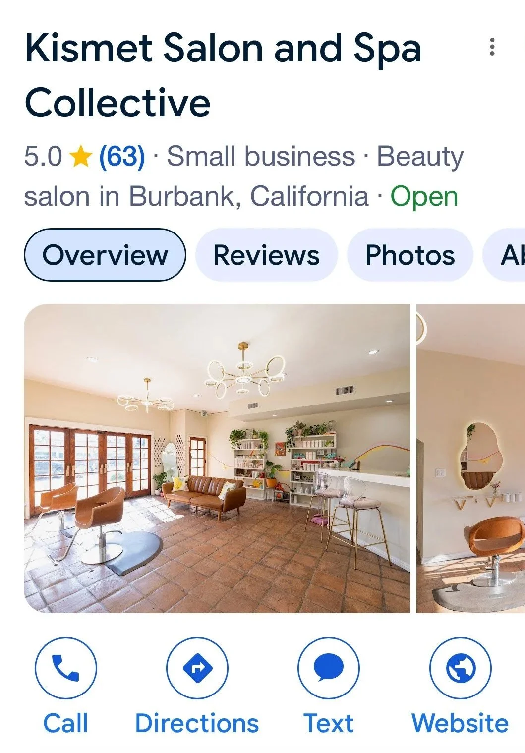 Screenshot of Kismet's Google Business Account showing Interior of a cozy, modern beauty salon with terracotta tiled flooring, seating area with sofa and chairs, white walls, large glass doors, and shelves with plants and beauty products.