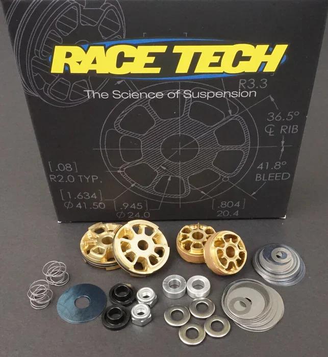 Race Tech suspension parts and a box labeled 'Race Tech The Science of Suspension' with technical diagrams.