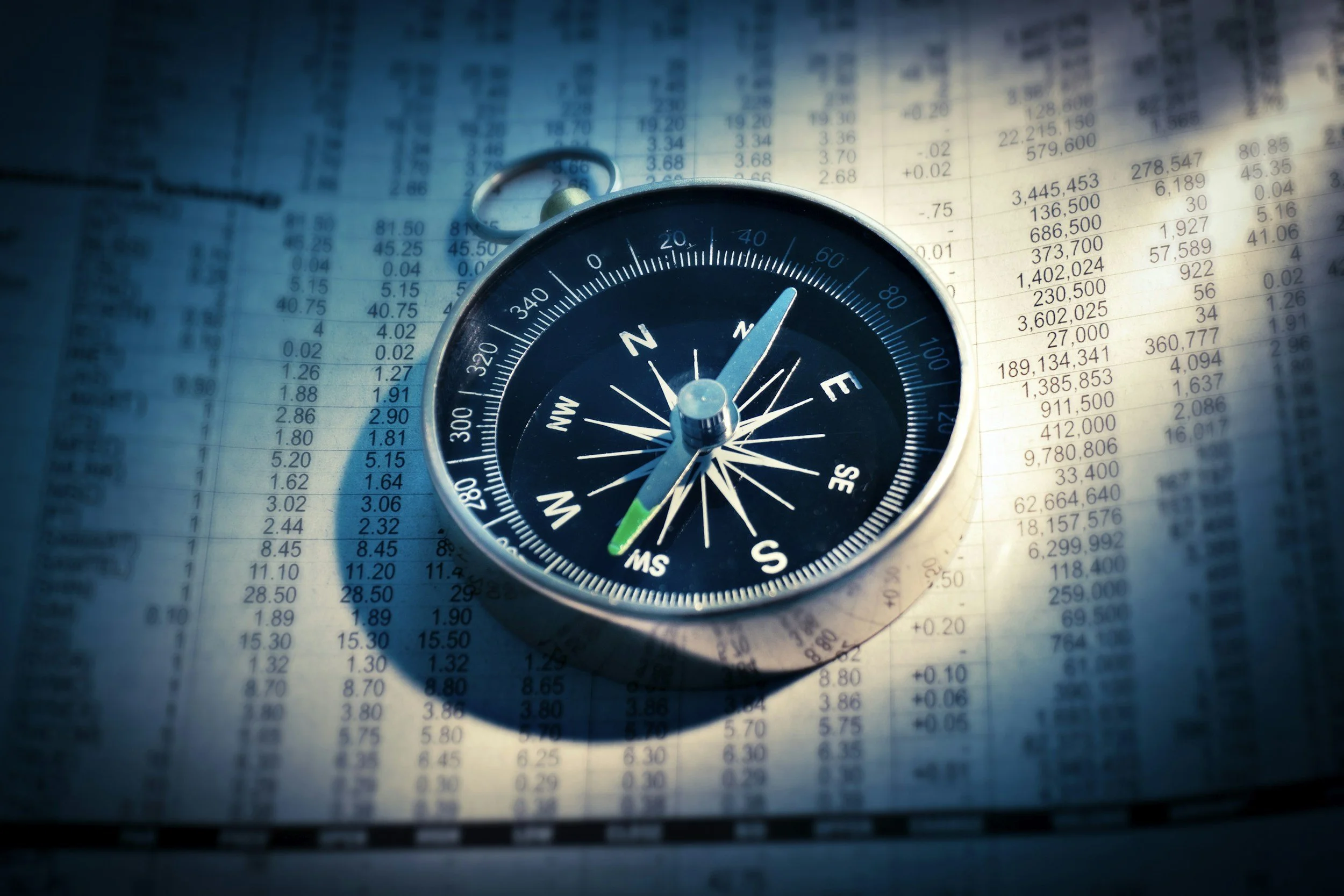 Compass resting on financial data, symbolizing guidance through the clinical trial process