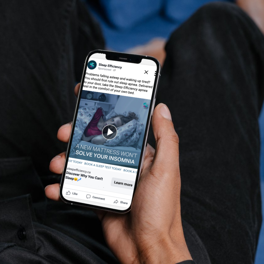 Person holding smartphone displaying an advertisement promoting sleep and a mattress for insomnia relief.