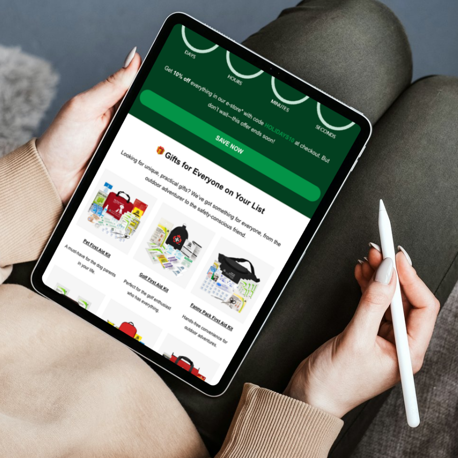 Person holding a tablet displaying an online gift shop with holiday promotion banner at the top and various gift kits listed below.