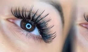 Close-up of a woman's eye with dramatic long false eyelashes and a blue contact lens.