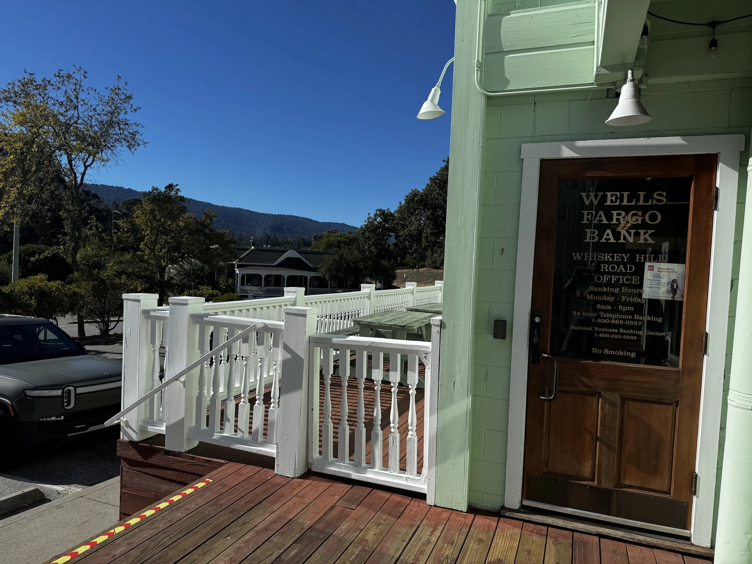Wells Fargo Bank at Woodside Town Center in California, with surrounding hillside views and village-style architecture.