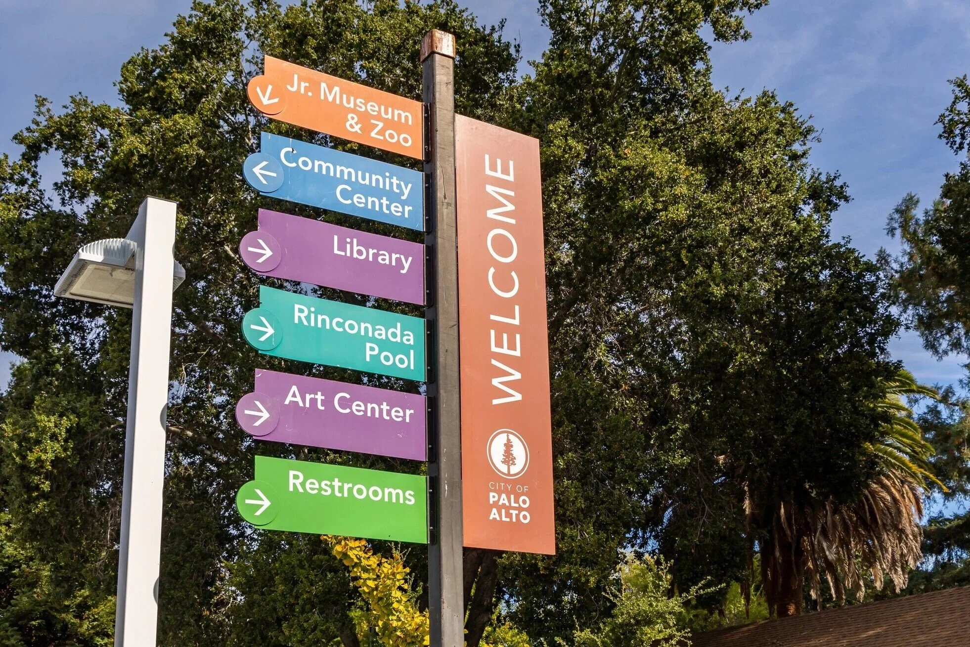 Directional sign at the Palo Alto Community Center, indicating the Jr. Museum & Zoo, Community Center, Library, Rinconada Pool, Art Center, and restrooms.