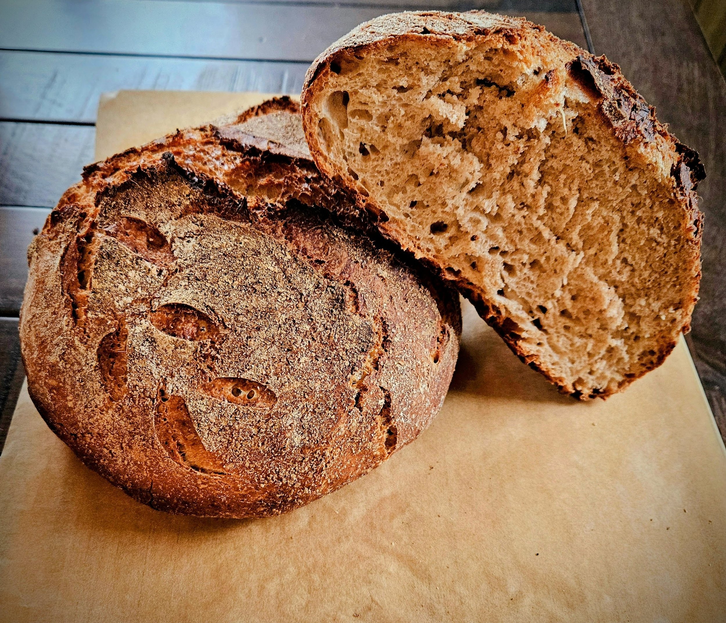 Rustic whole wheat boule with dark crackled crust and hearty open crumb, baked fresh in Antioch Illinois — Hauber Bread and Baking