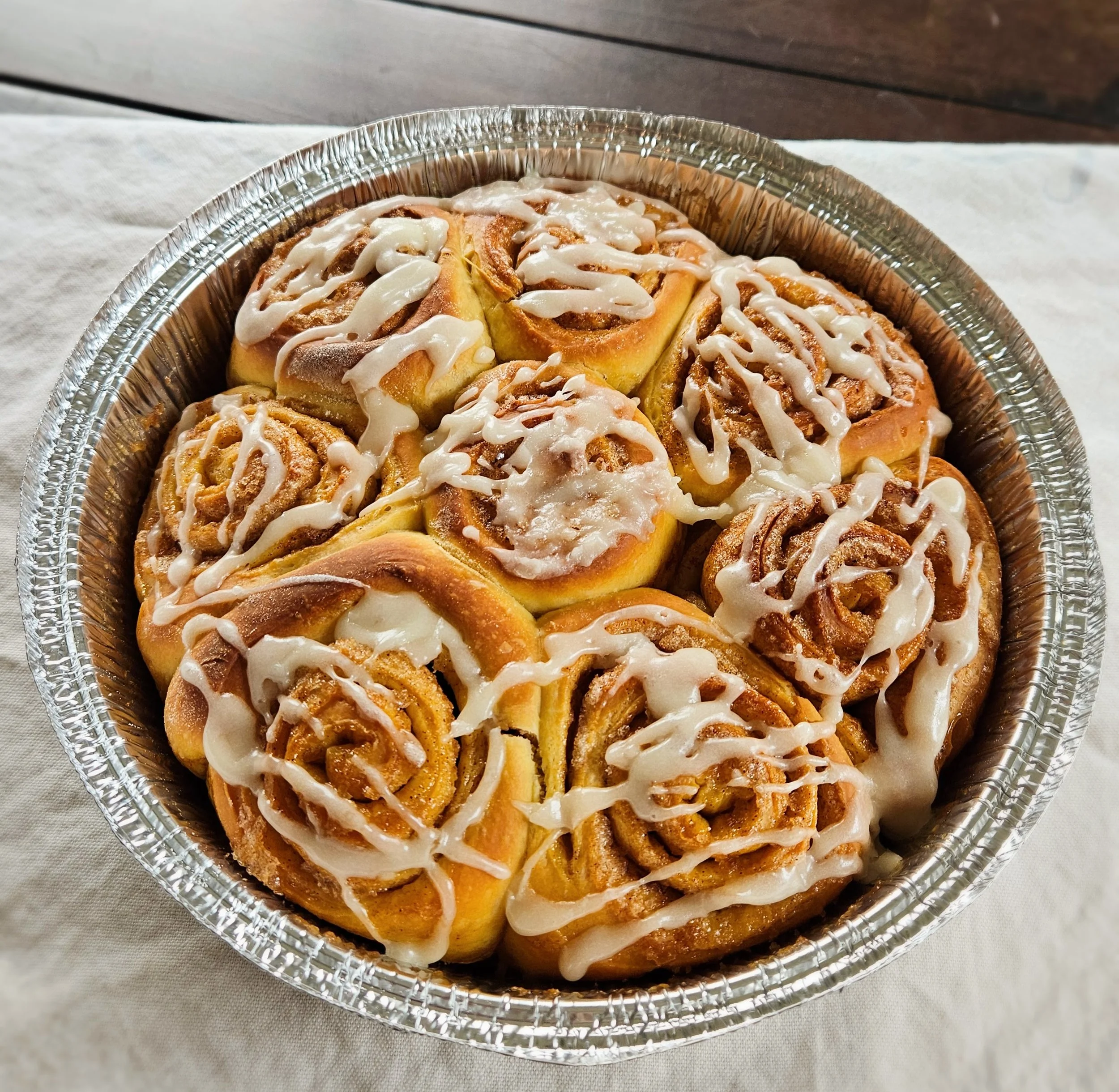 Homemade cinnamon rolls with vanilla glaze drizzled over golden soft-baked rolls in a 9-inch pan, 8-count seasonal item — Hauber Bread and Baking cottage bakery, Antioch IL