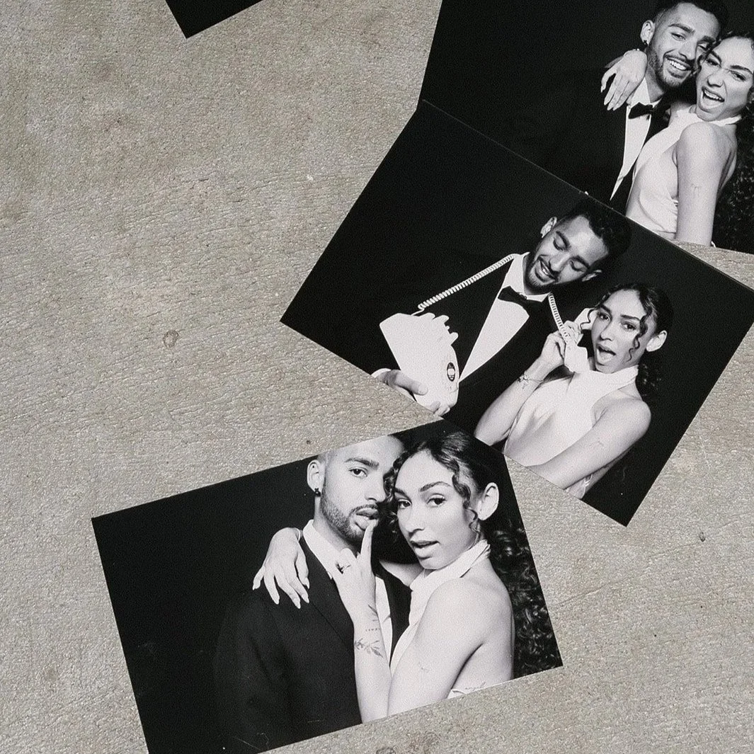 Black and white photo booth pictures of a couple dressed in formal attire, showing playful and affectionate poses.